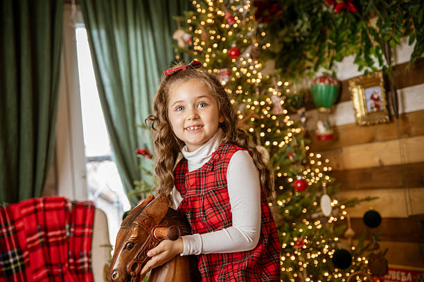 The little girl is enjoying her Christmas presents, and smiling.