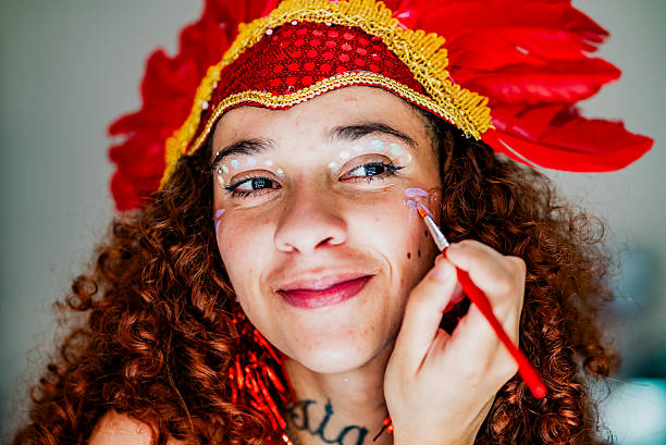Young woman putting on makeup for Carnival