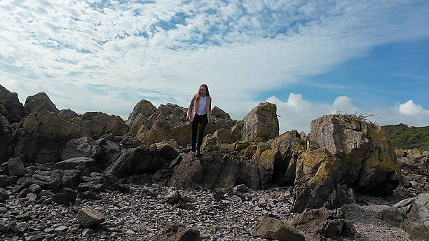 istock A Young Woman Adventurously Exploring the Beautiful Rocky Coastline Under 2253499688