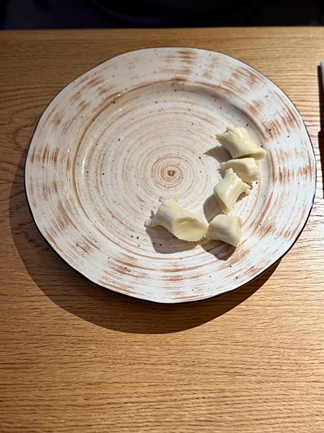 istock Plate With Bread Pieces And Crumbs, Minimal Serving, Soft Texture, Ceramic Rim, Wooden Table Surface, Warm Ambient Light, Inviting Rustic Snack Presentation, Closeup Detail 2253501103