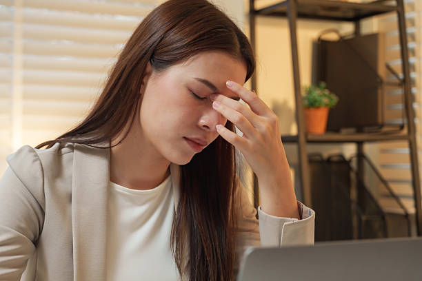 istock Asian woman closing eyes hand on forehead feeling stress and headache while working laptop representing fatigue burnout overwork pressure professional lifestyle corporate technology 2253504590