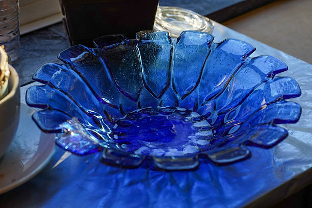 Blue handblown glass bowl with petal-shaped rim on table