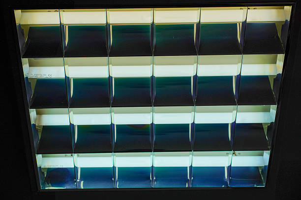 Abstract close-up of fluorescent ceiling light fixture with reflective louvers
