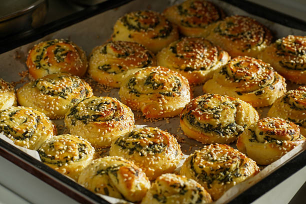 Freshly baked savory spiral rolls topped with sesame seeds and herbs