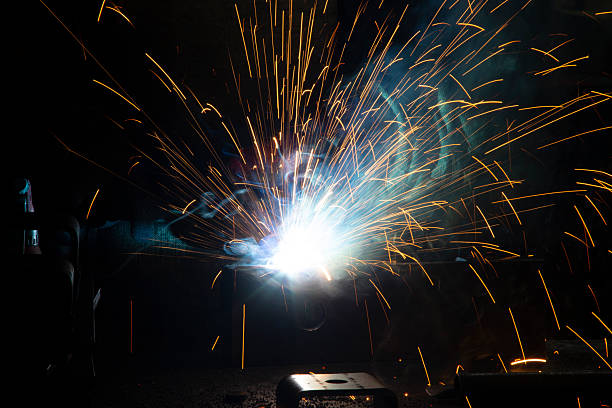 istock Sparks flying from an electrode during welding work performed by a professional welder in difficult conditions of darkness and night, the danger of violating safety regulations, background with a blurred bokeh effect 2253509292