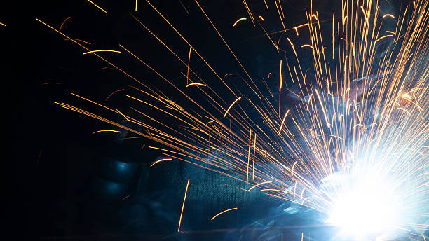 istock Sparks flying from an electrode during welding work performed by a professional welder in difficult conditions of darkness and night, the danger of violating safety regulations, background with a blurred bokeh effect 2253509301