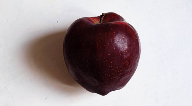 Burgundy-colored Gala apple on a white background