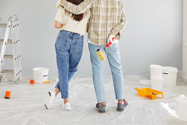 istock A couple with paint rollers looks at the wall, back view 2253518567