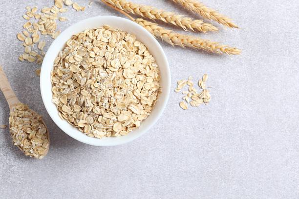 istock Composition with oatmeal flakes on gray background. Cooking breakfast 2253523737