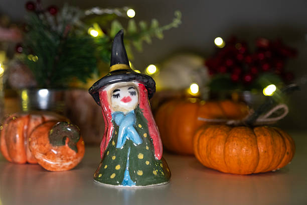 Handmade porcelain witch among pumpkin figurines