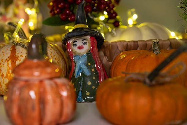 Handmade porcelain witch among pumpkin figurines