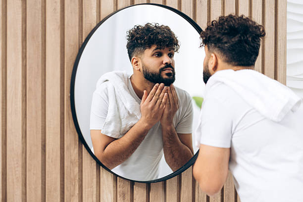 istock Handsome middle eastern man examining beard in bathroom mirror at home 2253531146