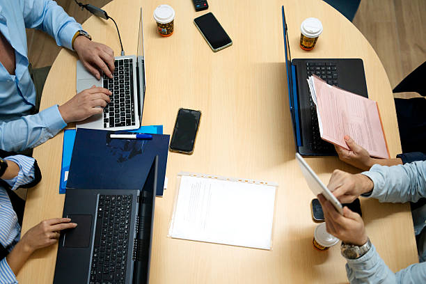 Professionals using devices and documents for teamwork in a corporate setting