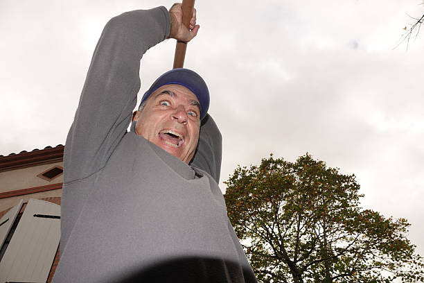 Golfer practicing swings at a driving range under clear blue skies.