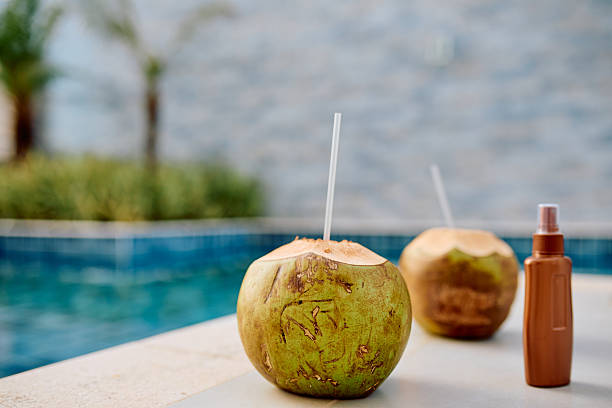 istock Coconuts with straws by swimming pool offering summer hydration 2253535505