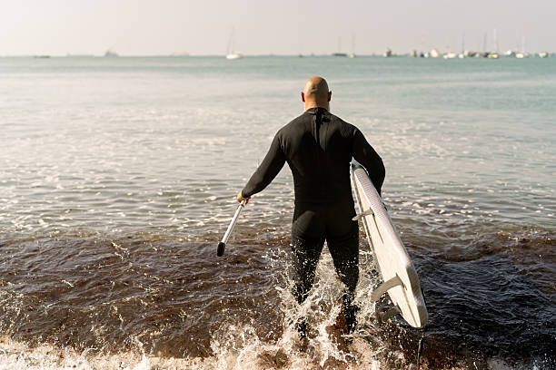 The Pacific Rim National Park in British Columbia on April 26, 2024: Young male surfer entering the ocean for a session at Pacific Rim National Park on Vancouver Island, British Columbia