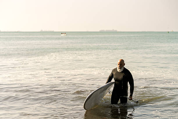 Palma de Mallorca, Spain - March 4, 2025 - Surfer swimming on a board on a sunny day, water sport
