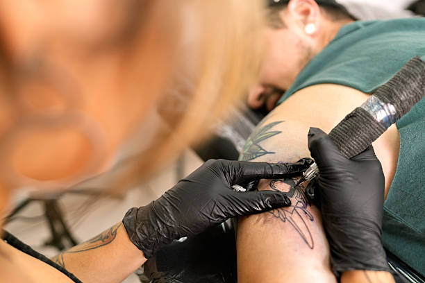 istock Tattoo artist working on new design for client 2253538546