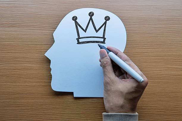 istock Conceptual image of a hand drawing a crown inside a head. 2253538725