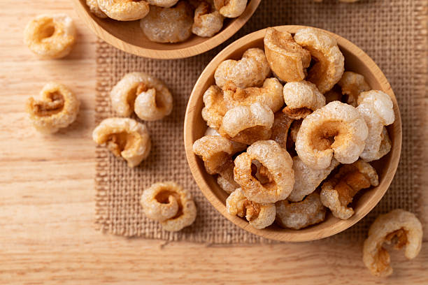 istock Pork rind in a wooden bowl, Table top view 2253539953