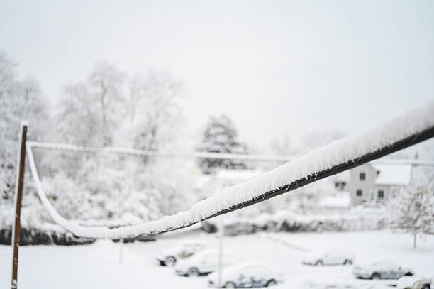 Back country skier climbing a mountain slope, along the line of an old, abandoned ski lift, in a windy and cold winter day.