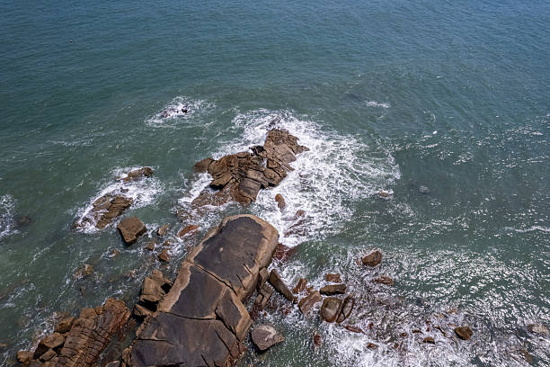 The waves crashed against the rocks, whipping up spray.