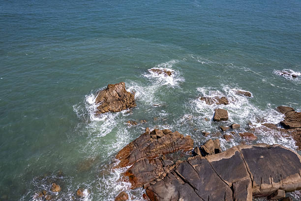 The waves crashed against the rocks, whipping up spray.