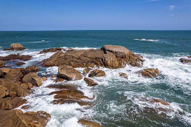 The waves crashed against the rocks, whipping up spray.