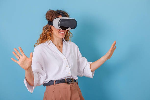 istock Woman wearing a vr headset, immersed in a virtual experience with hands gesturing in a digital environment 2253543799