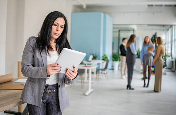 istock Office environment with adults working together on tasks and engaging in discussions during a typical weekday 2253544264