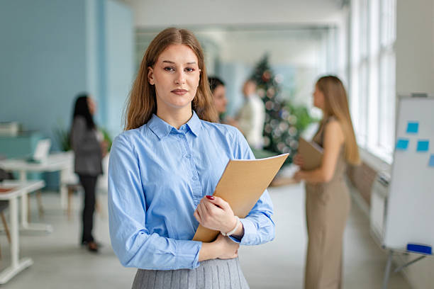 istock Professional woman holds folder while coworkers engage in discussion in an office setting during daytime hours 2253545174