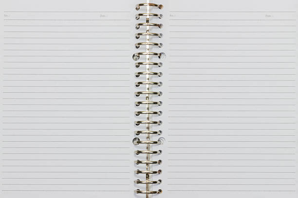 open notepad with checkered sheets, golden spiral, close-up from above on white background