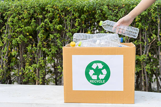 istock Hand putting plastic bottle into recycling box with recycle symbol, outdoor waste sorting 2253548497