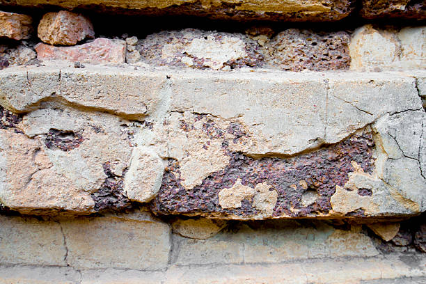 Background texture of old brick wall with peeling plaster, Thailand.