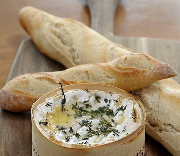 istock Baguette Bread and Warm Soft Cheese on a Bread Board 2253550197