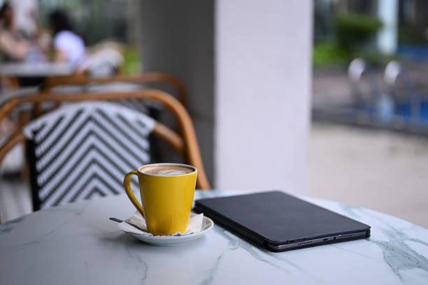 Espresso coffee in yellow cup on the stone table with blurred background