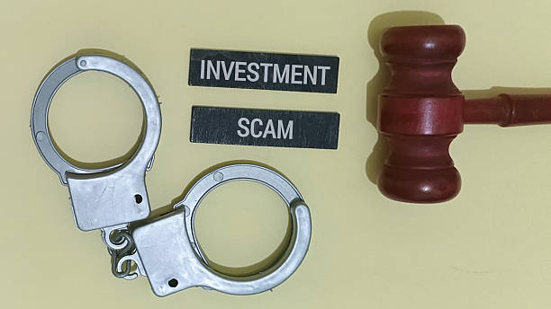 istock Handcuffs and gavel with investment scam blocks on table 2253552851