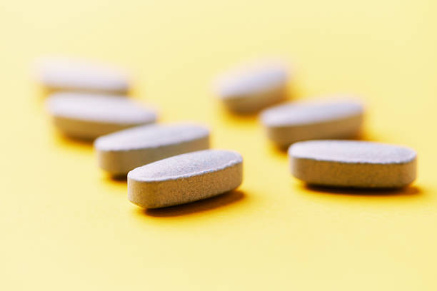 istock Multivitamin tablets on bright paper background. Close up. Copy space. 2253553827