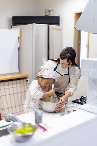 Mother and daughter making cookies in kitchen - high angle view