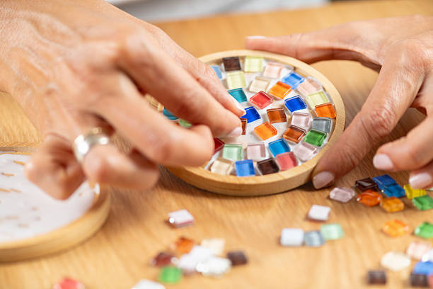istock Arranging small craft pieces and gluing them onto coasters in a home studio. Captures precision, texture control, and focused creative workflow. 2253558390