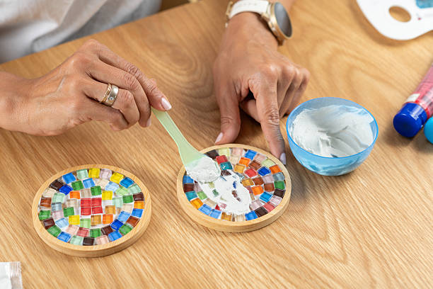 istock Woman coating handmade coasters with a fixator topcoat during a home craft session. Highlights precision, surface protection, and careful finishing technique. 2253558510