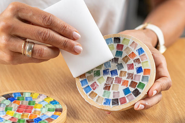istock Woman completing coaster surface by adding a fixator finish in a home studio. Captures material focus, steady hand technique, and decorative protection. 2253558561