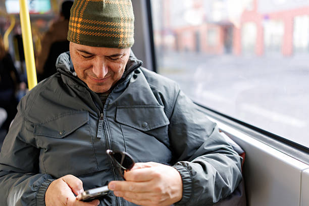 istock Mature man using smart phone while traveling by train during cold winter day 2253558584