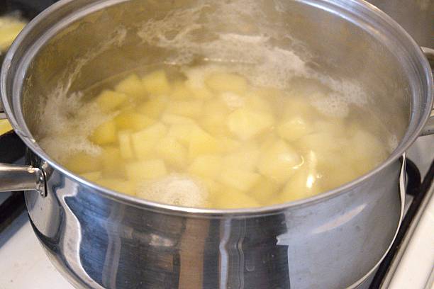 istock Cooked Diced Potato in Water in Cooking Pan Close-Up 2253559159