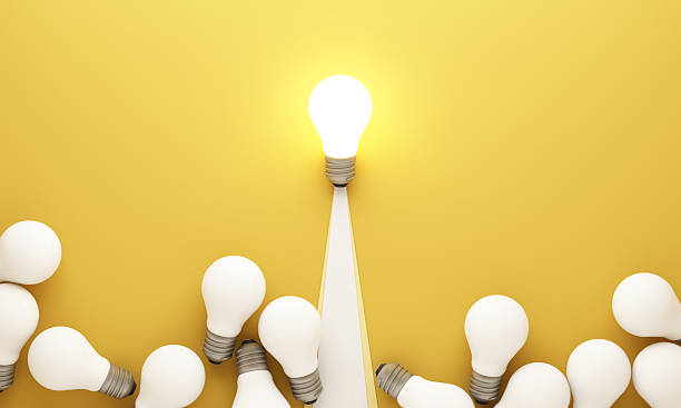 istock Leadership and innovation concept with one bright light bulb rising above many unlit bulbs on yellow background symbolizing unique idea success and creativity 3d rendering 2253559273