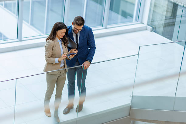istock Business colleagues collaborating on mobile phone in modern hallway 2253559371