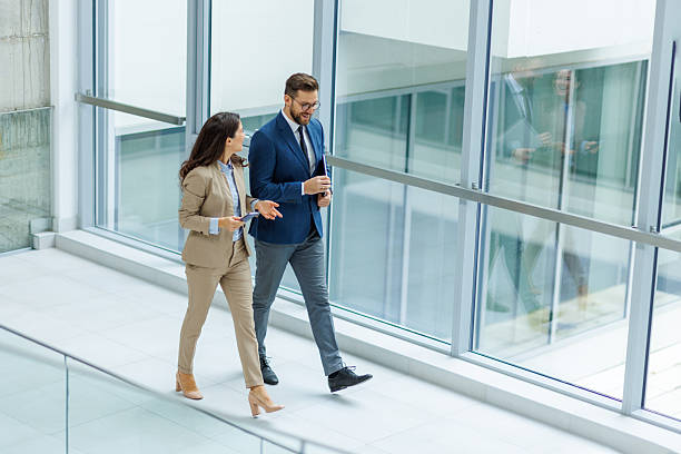 istock Business people walking and discussing in modern office building 2253559377