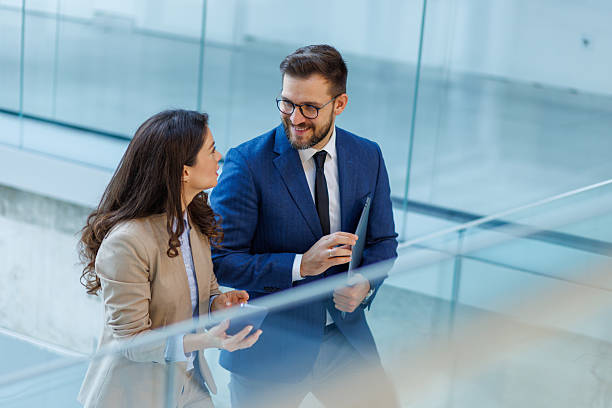 istock Business professionals discussing strategy while walking downstairs 2253559401