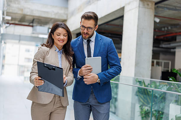 istock Business colleagues collaborating on project in modern office hallway 2253559408