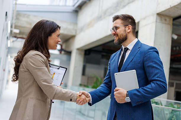 istock Business colleagues shaking hands in a modern office building 2253559418